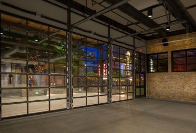 interior view of the 800 congress event space facing the patio and outside area at night